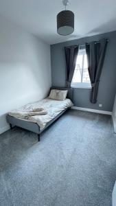 a bedroom with a bed and a window at Tobar Oisinn in Oban