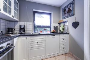 a kitchen with white cabinets and a window at Oberhausen an der Nahe einfach nur schön in Oberhausen +10 photos