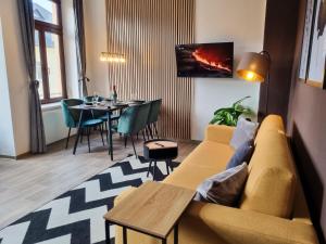 sala de estar con sofá amarillo y mesa en maremar - Design Maisonette Altstadt - 4 Personen - Luxus Boxspringbett - Vollausstattung, en Greiz