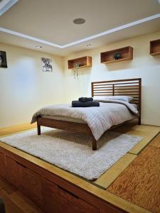 a bedroom with a large bed with a wooden headboard at Wood studio flat in London