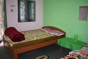 1 dormitorio con cama y mesa verde en MANAS RAY HOMESTAY, en Jyoti Gaon