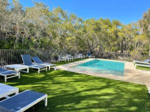 a swimming pool with lounge chairs in a yard at Nature View #3 in Fort Myers Beach