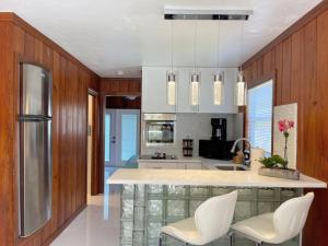 a kitchen with white chairs and a large kitchen island at Nature View #3 in Fort Myers Beach