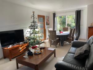 a living room with a christmas tree and a couch at La Maringote in Cerisy-la-Forêt