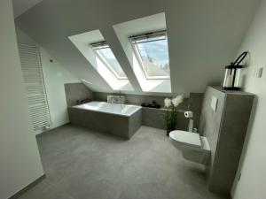 a bathroom with a sink and a tub and a toilet at Ferienhaus Mountain View Six53 mit Sauna und Kamin in St. Andreasberg in Sankt Andreasberg +45 photos
