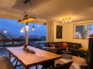 - un salon avec une table et un canapé dans l'établissement Ferienhaus Mountain View Six53 mit Sauna und Kamin in St. Andreasberg, à Sankt-Andreasberg