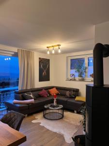 a living room with a couch and a table at Ferienhaus Mountain View Six53 mit Sauna und Kamin in St. Andreasberg in Sankt Andreasberg