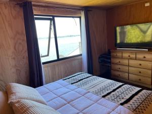 a bedroom with a bed and a large window at Departamento con vista al Mar in Ancud