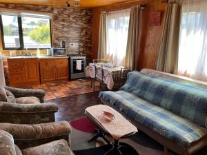 sala de estar con sofás, mesa y cocina en Departamento con vista al Mar, en Ancud