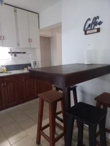 uma cozinha com uma grande mesa de madeira e bancos em Casa Luz em Neuquén