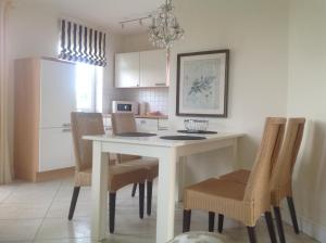 a kitchen with a table and chairs and a refrigerator at Urlaubsglück Familien- & Hunde-Paradies in Rankwitz