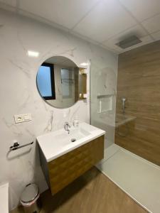 a bathroom with a sink and a shower and a mirror at Apartamento Isabel in Caravaca de la Cruz