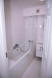 a white bathroom with a tub and a sink at Stunning 2-Bed Apartment in London in London