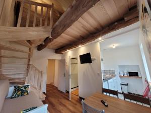 a room with wooden ceilings and a table and chairs at Gite et chambres de la porte du parc in Les Iffs