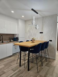 a kitchen with a wooden table and blue chairs at Habitación céntrica de Lujo Gv 3 in Valencia