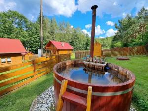 un grand tonneau en bois avec un étang dans une cour dans l'établissement Hiša na Planini, 