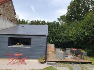 un petit hangar avec une table et des chaises sur une terrasse dans l'établissement Studio de charme indépendant avec terrasse, à Les Chéris