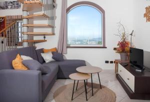 - un salon avec un canapé bleu et une table dans l'établissement Splendida Casa in Centro a Barbaresco, à Barbaresco