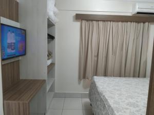 1 dormitorio con 1 cama, TV y ventana en Temporadas L'acqua DiRoma, en Caldas Novas