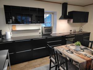 a kitchen with black cabinets and a wooden table at Pakri Parun in Paldiski