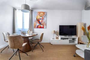 ein Wohnzimmer mit einem Tisch und einem TV in der Unterkunft CŒUR DU VENTOUX Carpentras Bel appart 6 places in Carpentras