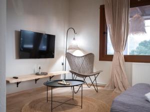 a living room with a tv and a table and a chair at Seaview Apartment - Poros Relaxing Beachfront Flat in Poros