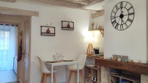 uma sala de jantar com uma mesa e um relógio na parede em Blois City - Le Petit Saint Jean em Blois