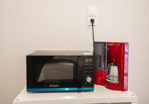 eine Mikrowelle auf einer Theke neben einer Kaffeemaschine in der Unterkunft Apartment 105 sq.m. near center in Patras