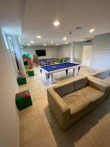 a living room with a couch and a ping pong table at Destinar Apart in Carilo