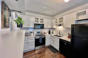 a kitchen with white cabinets and a black refrigerator at 1 Bd Hide away Historic Dayton, Oh Oregon District in Dayton