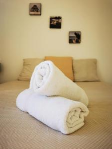 a pile of towels sitting on top of a bed at Grand appartement a 300M de la plage in Sainte-Maxime
