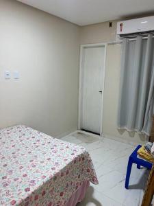 1 dormitorio con 1 cama con manta de flores en Casa aluguel Emissario Arembepe en Arembepe