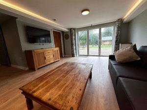 a living room with a couch and a wooden coffee table at Lakeview Holidays in Whelford