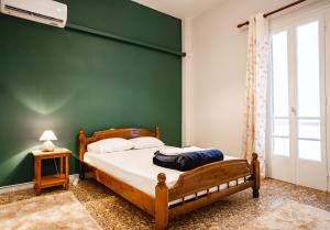 ein Schlafzimmer mit einem Bett mit einer grünen Wand in der Unterkunft Apartment 105 sq.m. near center in Patras