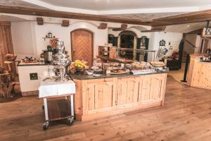 a kitchen with an island in the middle of a room at Dorfhotel Beludei in Santa Cristina in Val Gardena