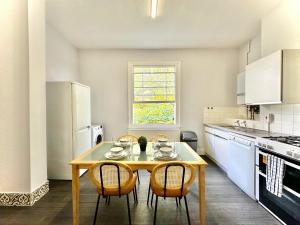 a kitchen with a table and chairs in a kitchen at Enticing 2 Bed 2 Bath Flat in Hackney with garden in London