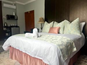 Una cama con un animal de peluche encima. en Silken Trap Accommodation NO LOADSHEDDING en Johannesburgo