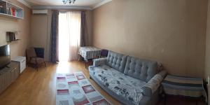 a living room with a couch and a television at Apartment in Tskaltubo - # 1 in Tsqaltubo