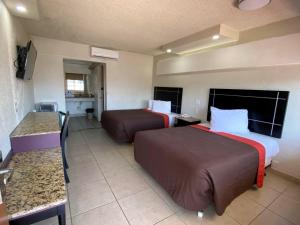 a hotel room with two beds and a kitchen at Motel Reno in Tijuana
