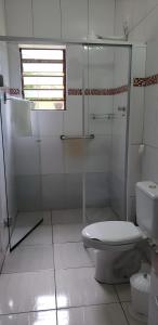 a bathroom with a toilet and a glass shower at Casa do Lago in Cunha