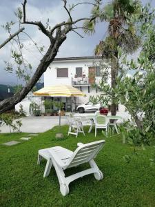 a table and chairs and an umbrella in the grass at La casa di Silvia in Massarosa