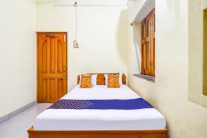 een slaapkamer met een bed in een kamer bij OYO Shivaye Rest House in Deoghar