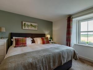 a bedroom with a large bed and a window at 3 Bed in Crieff 78313 in Madderty