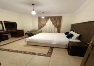 a bedroom with a bed and a desk and a television at فندق الافاق بالنسيم in Jeddah