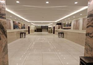 um longo corredor com mesas e pinturas nas paredes em فندق الافاق بالنسيم em Jeddah