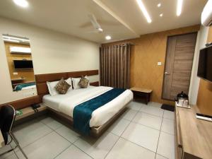 a hotel room with a bed and a television at Hotel Kinara in Ahmedabad