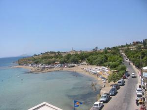 a beach with a bunch of cars parked next to the water at Hotel Avra in Egina