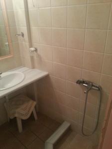ein Bad mit einem Waschbecken und einer Dusche in der Unterkunft Hotel Avra in Ägina Stadt