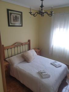 een slaapkamer met een wit bed met twee dienbladen erop bij La tranquila Manchuela in Alborea