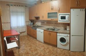 een keuken met een wasmachine en een magnetron bij La tranquila Manchuela in Alborea +13 foto's